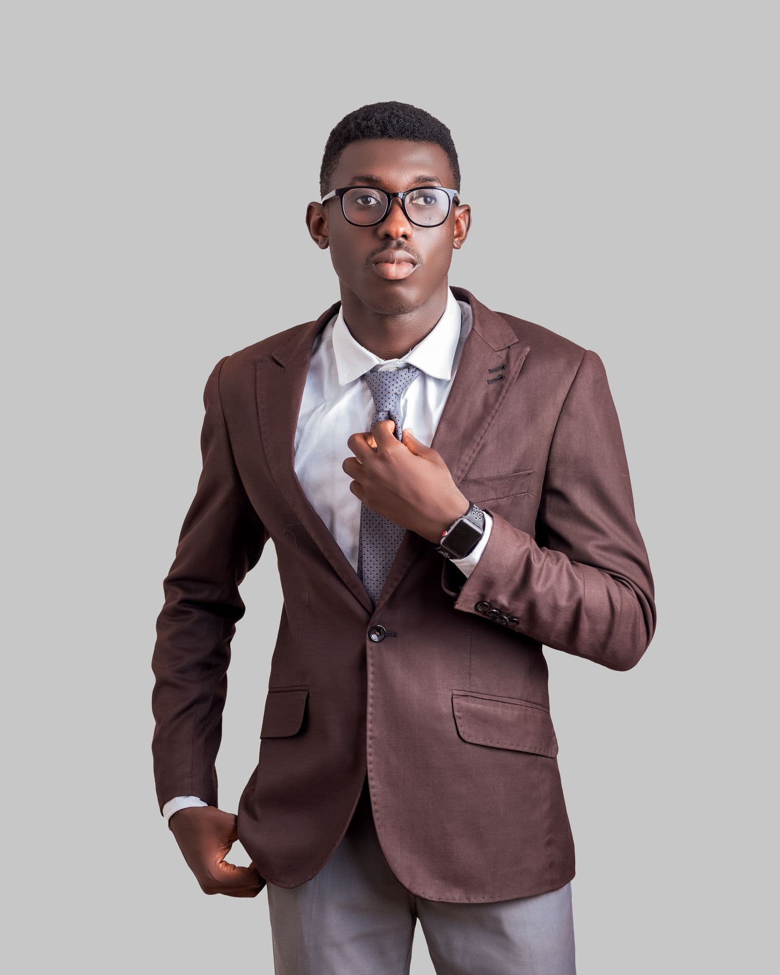 A studio portrait of a professional in a suit against a pale grey backdrop.